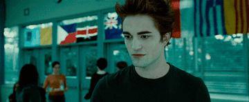 Edward Cullen smiling as he walks into the cafeteria