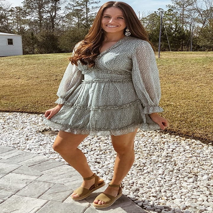 reviewer wearing the green and white dress