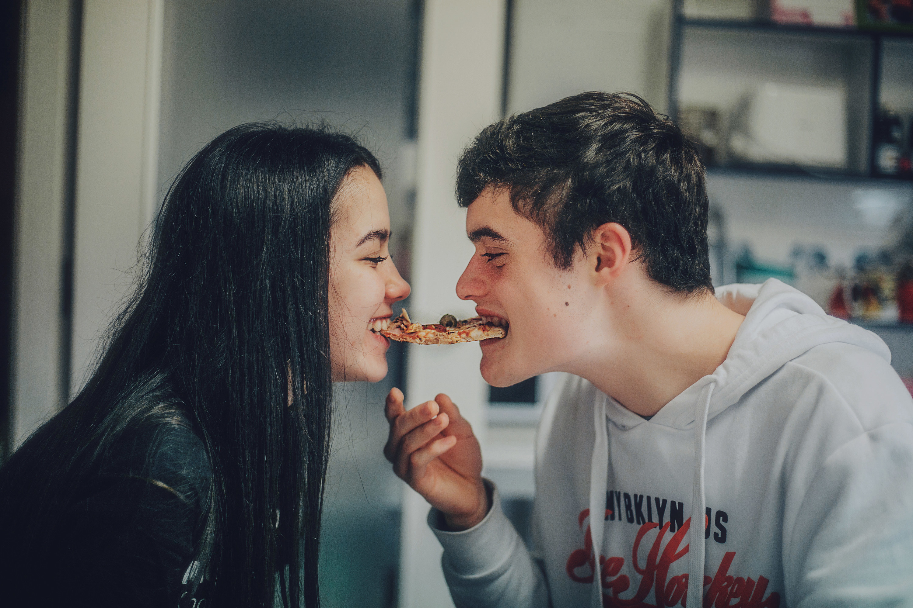 Couple biting a piece of pizza