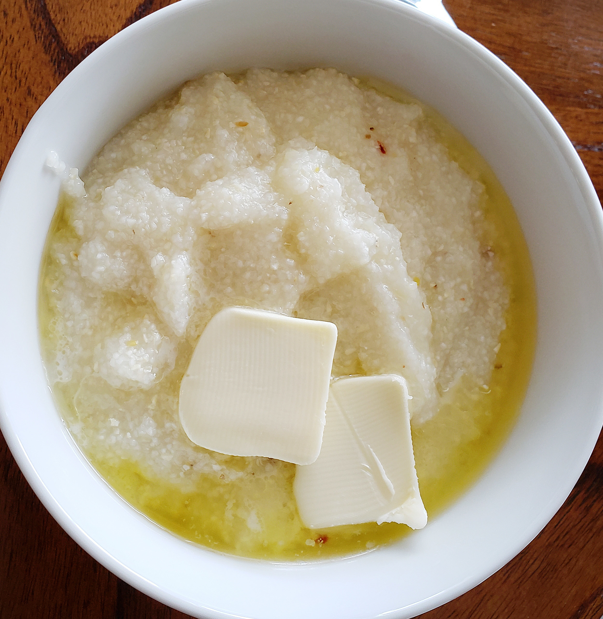 A bowl of grits with melted butter