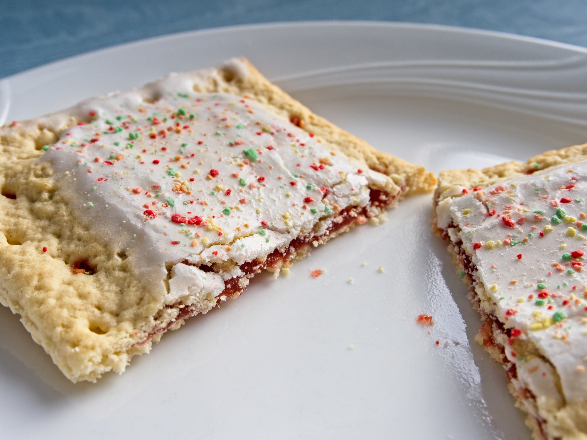 A toaster pastry with strawberry filling, vanilla icing, and sprinkles