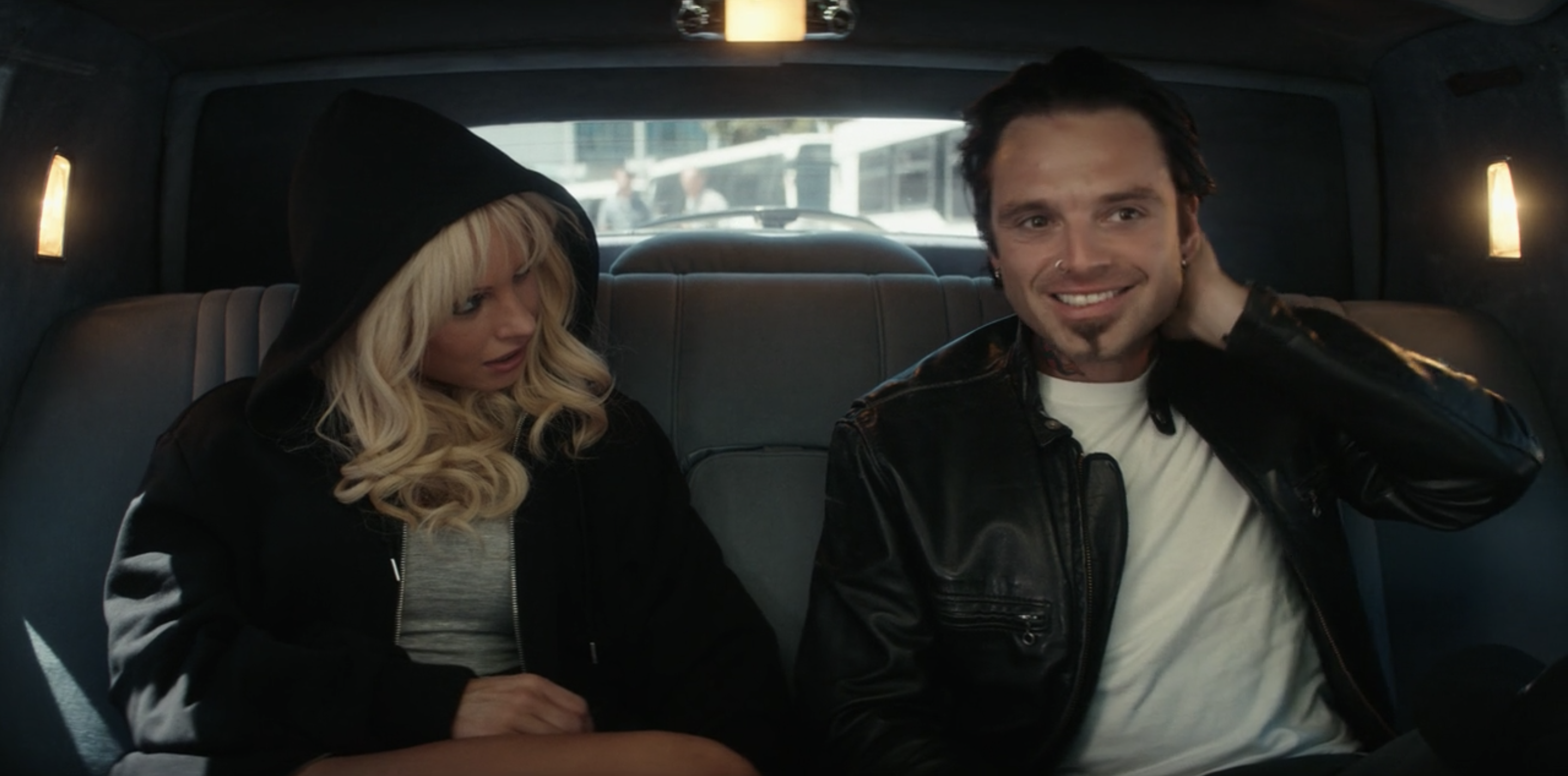 Lily James and Sebastian Stan sit in the back of a car as Pam and Tommy
