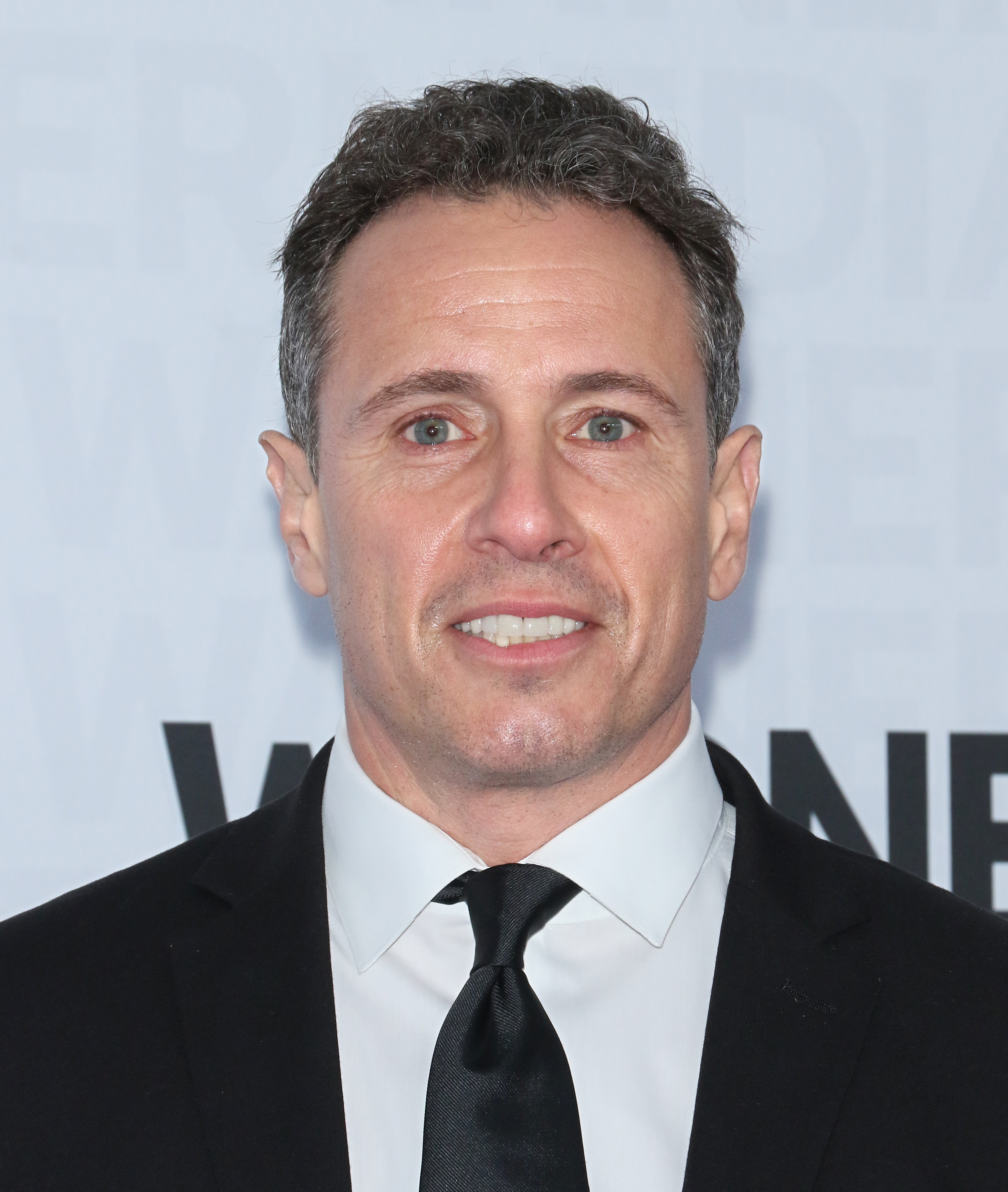 Chris Cuomo smiles in a suit