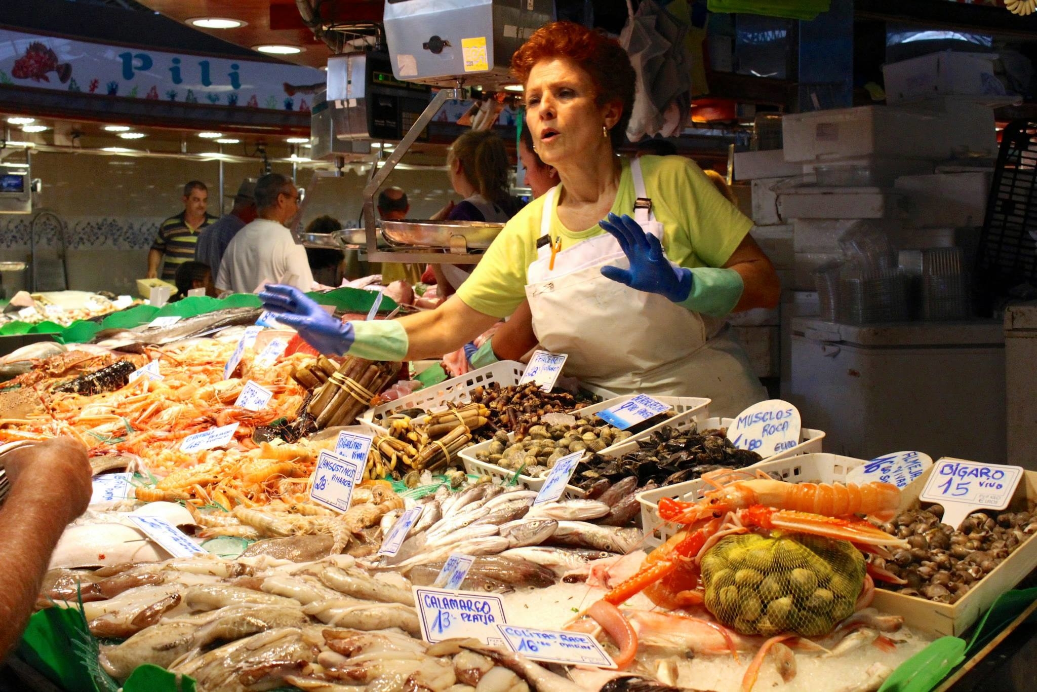 A woman at a seafood counter in a market.