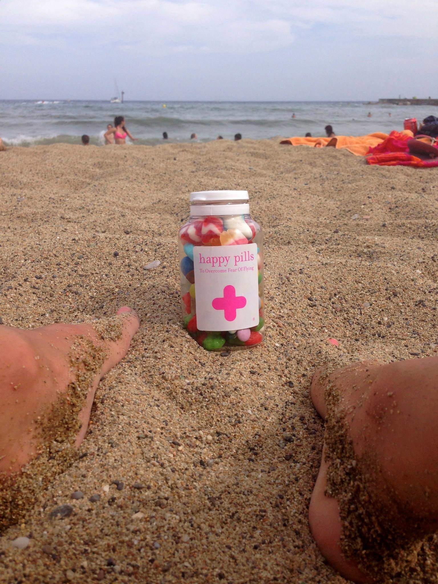 A bottle filled with candy in the sand