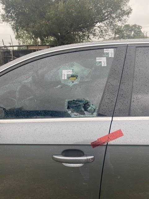 A smashed car window with two holes in the glass