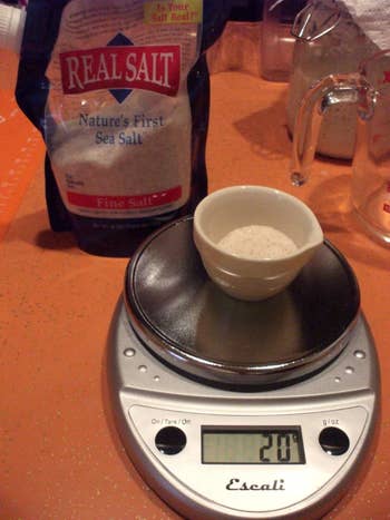 Kitchen scale being used to measure salt