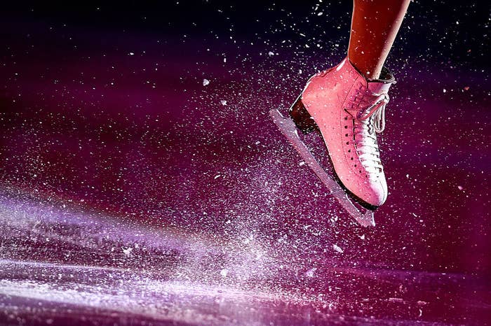 shot of a figure skater&#x27;s boot with ice flying up