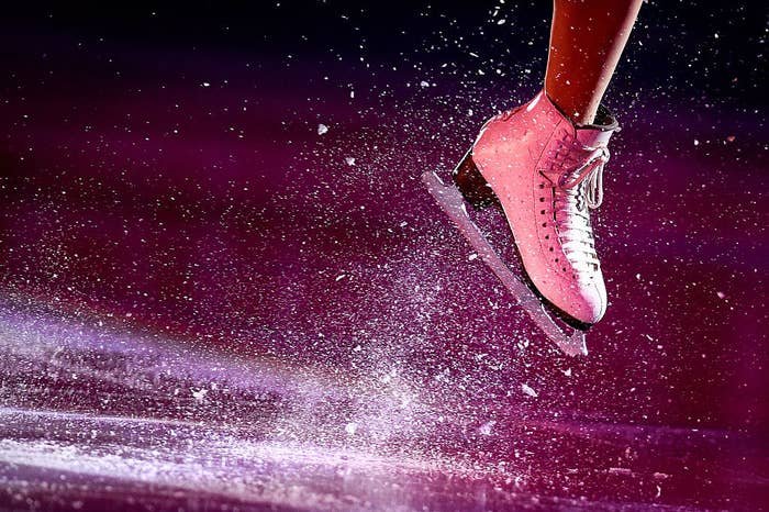 shot of a figure skater's boot with ice flying up
