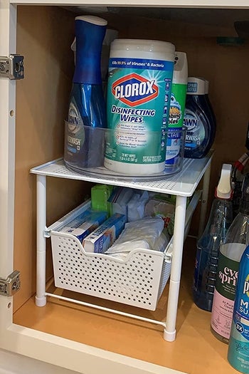 a reviewer showing cleaning products and trash bags in the drawer