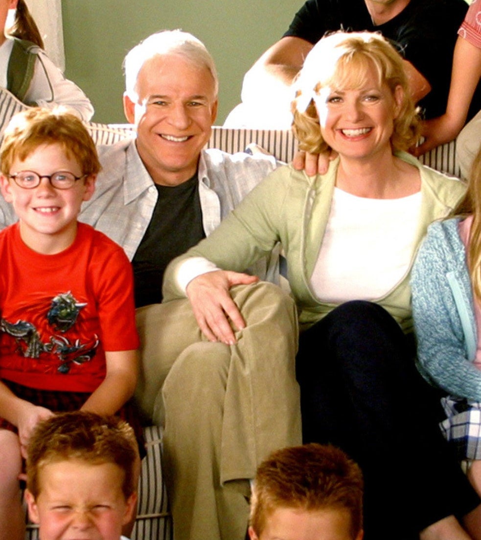 Jake sitting next to a dog in the cast photo for Cheaper By the Dozen