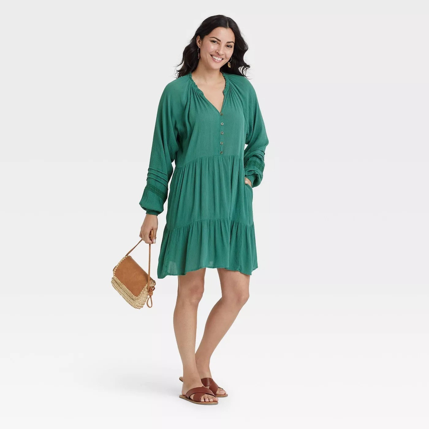 Model wearing green  midi dress with tiered skirt, stops above the knee