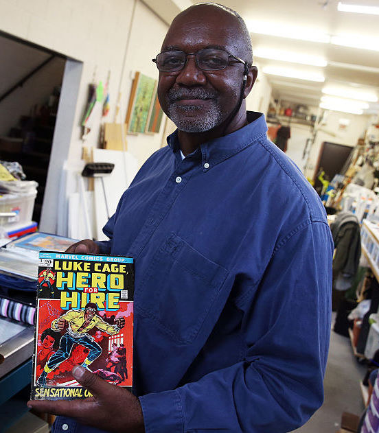Artist and collector Kerry James Marshall holding a Luke Cage comic