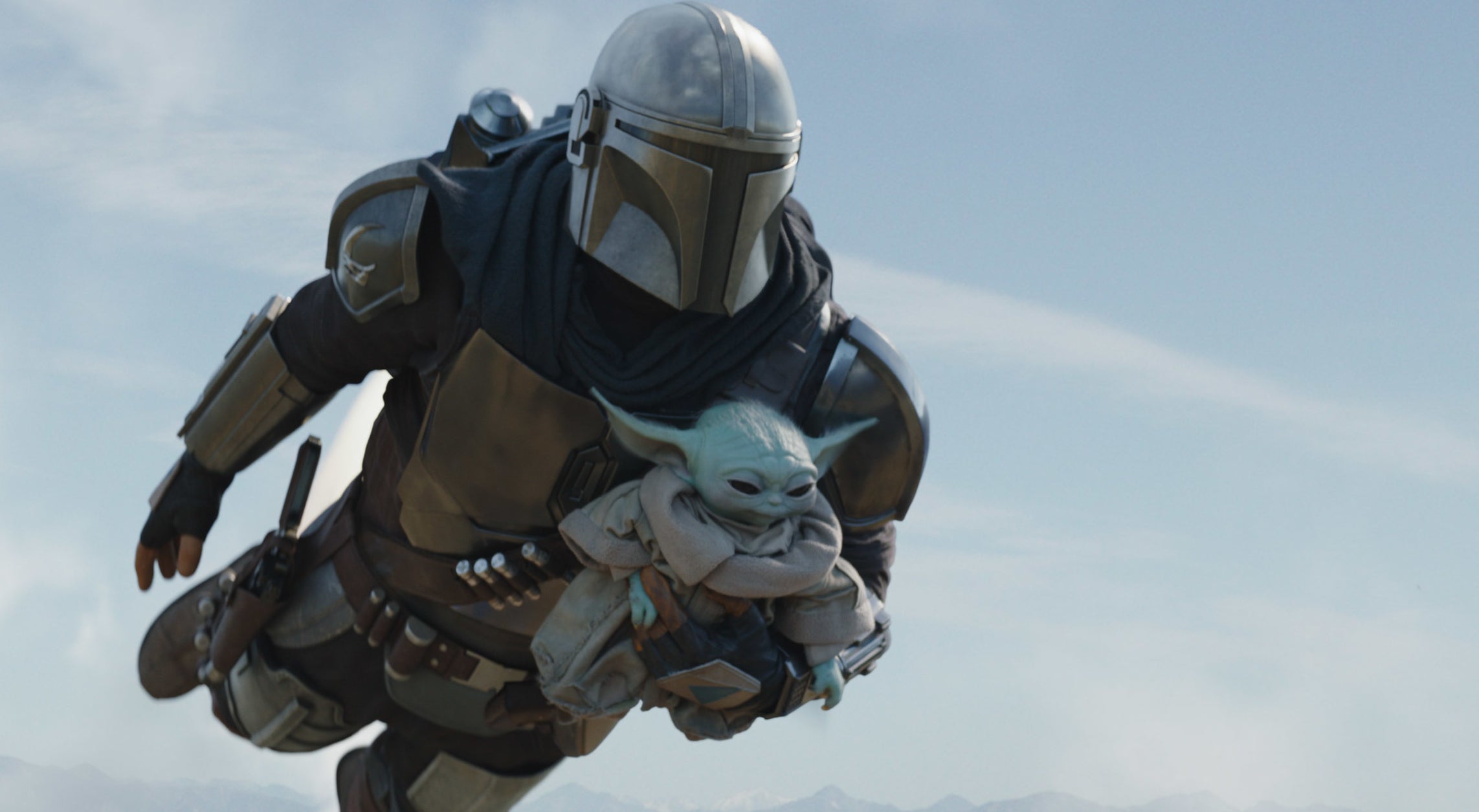The Mandalorian flies through the air with Baby Yoda