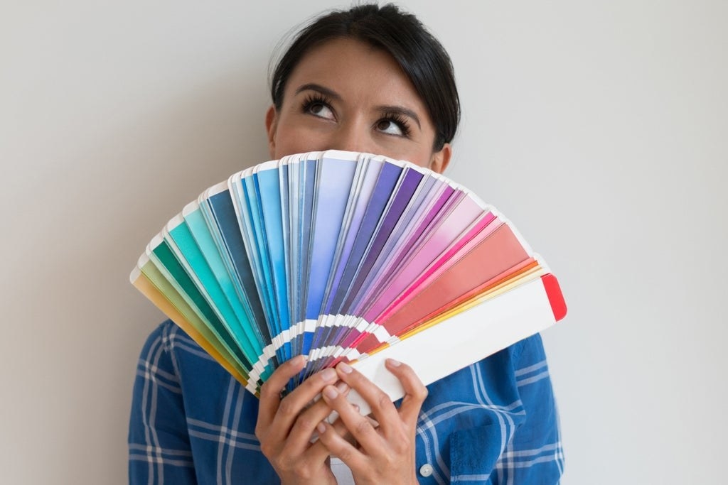 A woman fanning several swatches of paint color