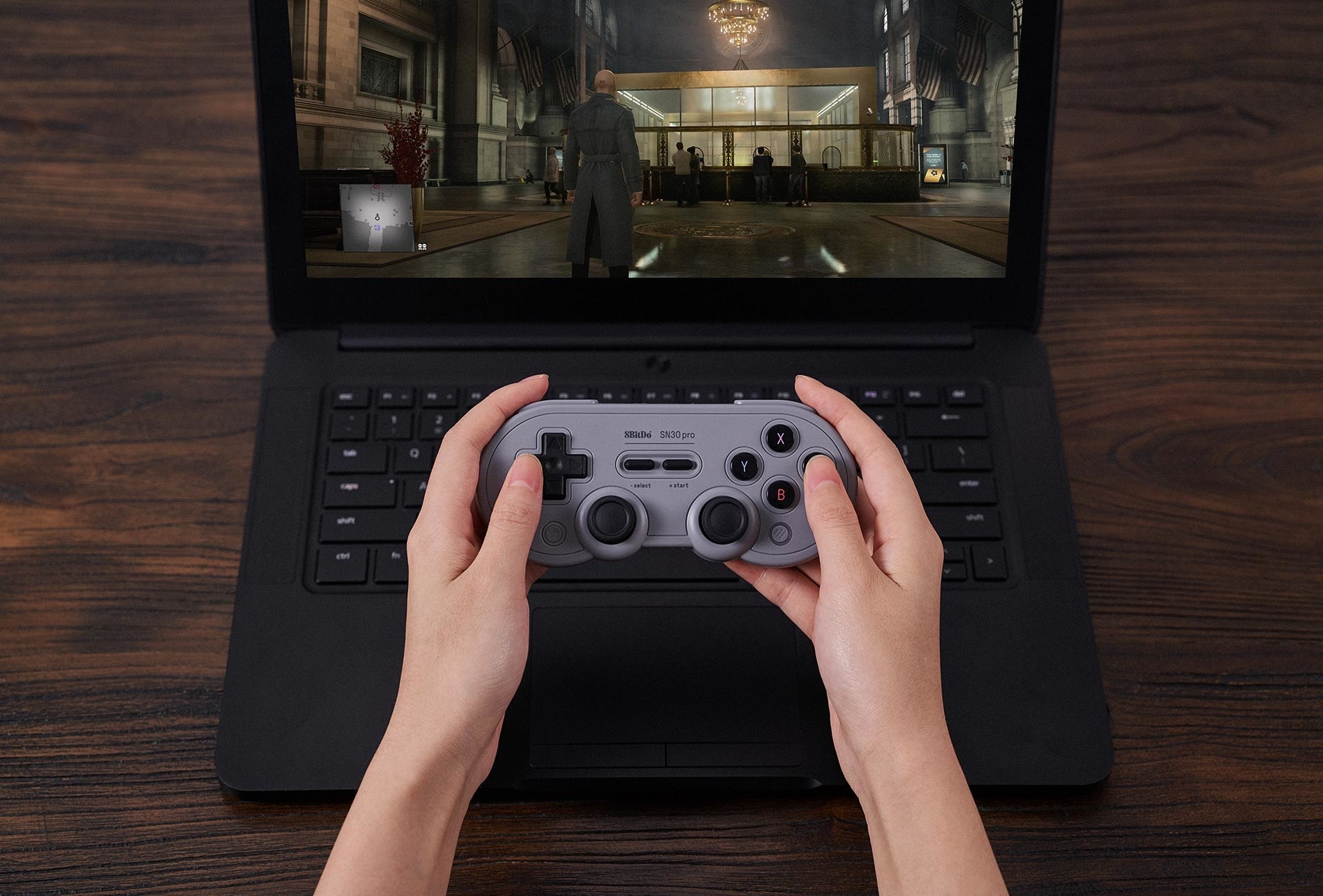 Someone using the controller to play a video game on a laptop