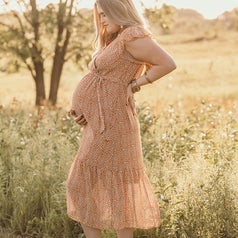 reviewer wearing the tan dress