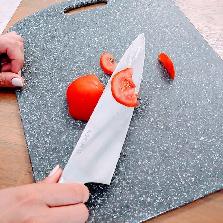 reviewer holding the knife showing a sliced tomato