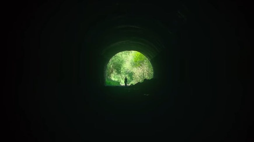 A mysterious figure standing at the end of a sewer tunnel in &quot;Men&quot;