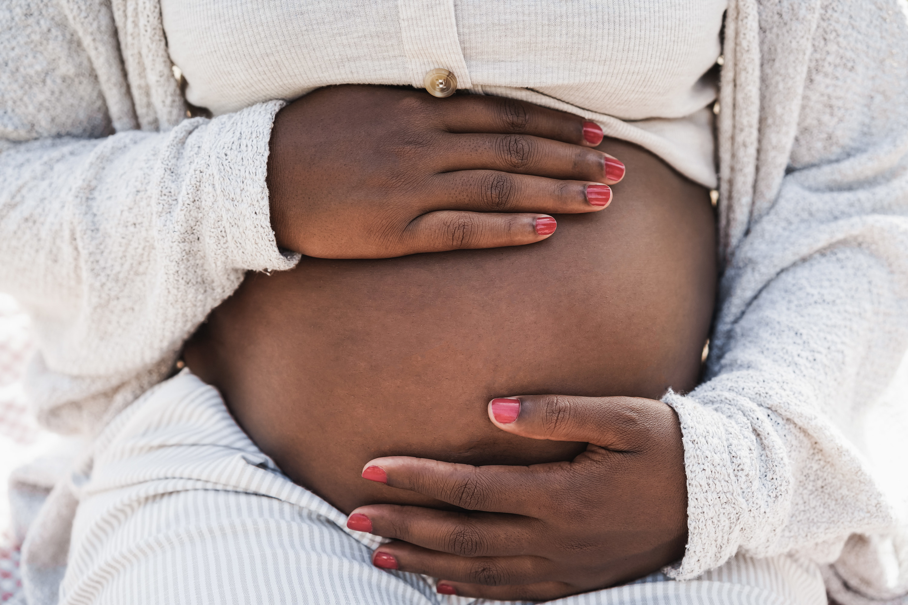 Close up of pregnant Black woman holding her belly