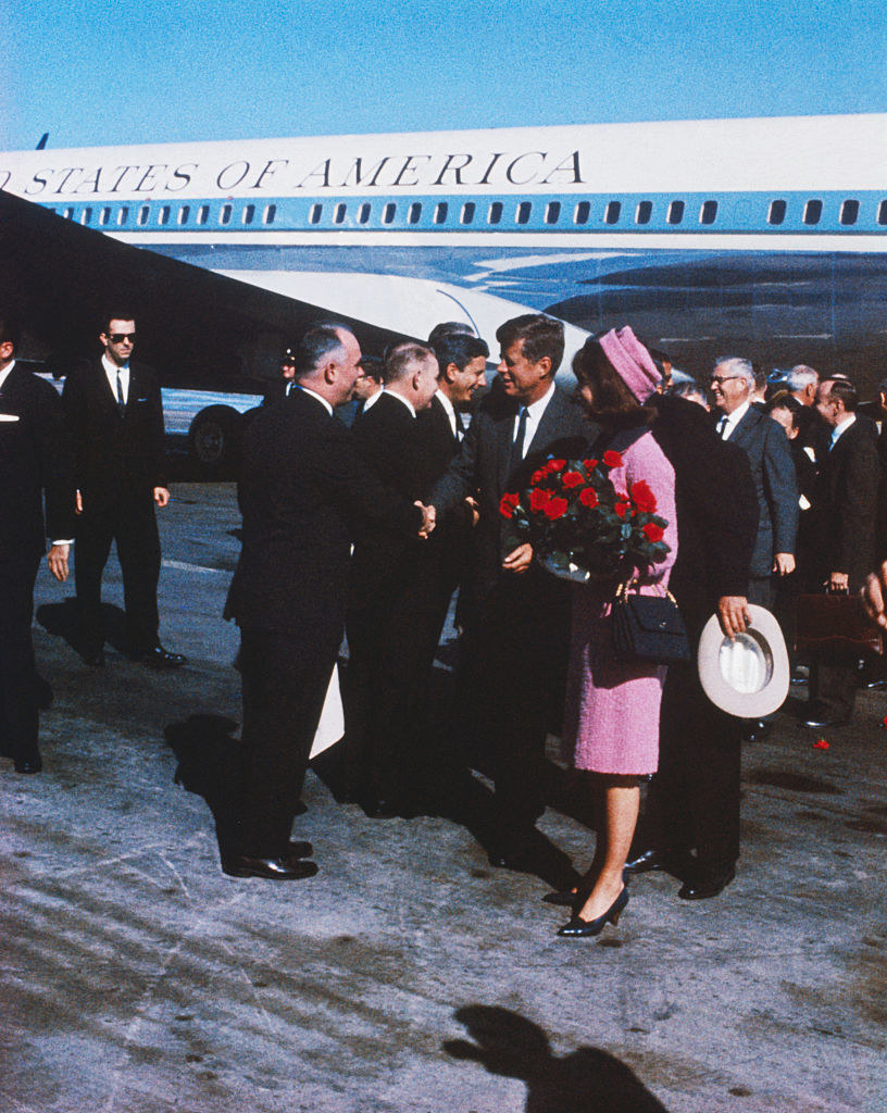 President and Mrs. Kennedy, carrying a bouquet of red roses, move down reception line, in dallas November 22nd,