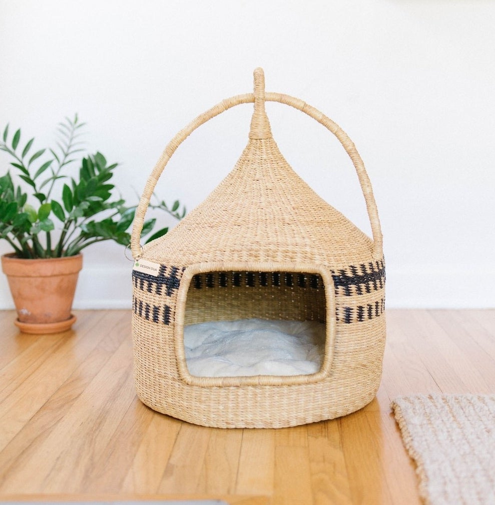 the woven cat bed with a white sherpa cushion inside