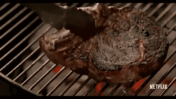 Putting a steak on a hot grill