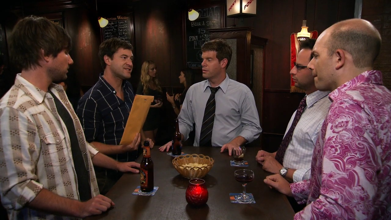 Main characters of The League gathered around a table