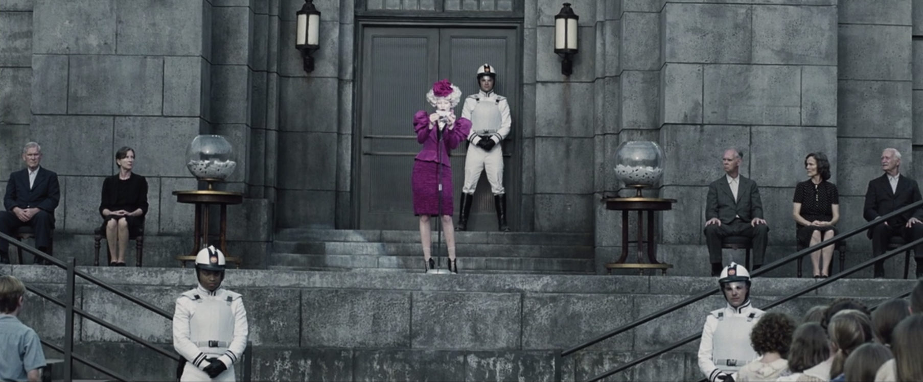 Effie in pink announcing the reaping