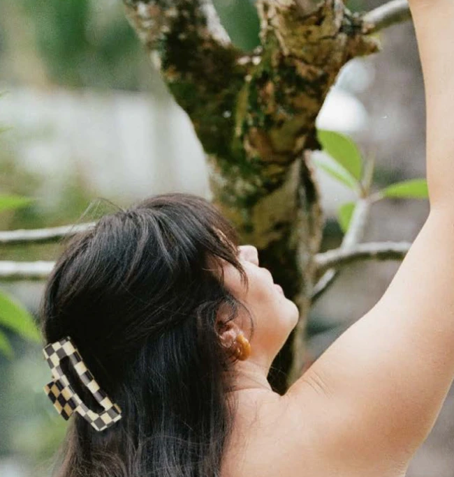 model wearing the black and cream checkered hair clip