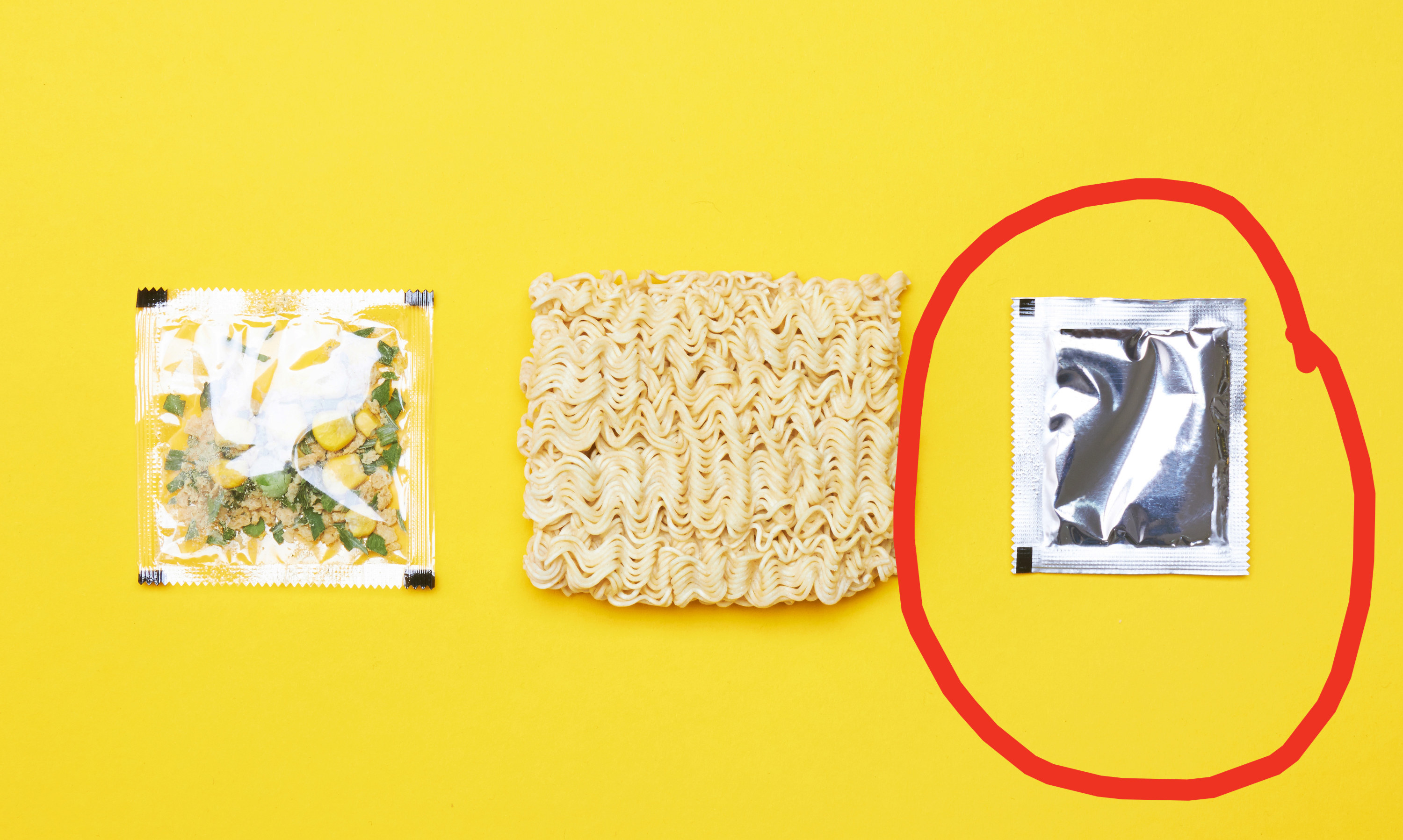 Ramen ingredients laid out on a yellow background with circle around the seasoning packet