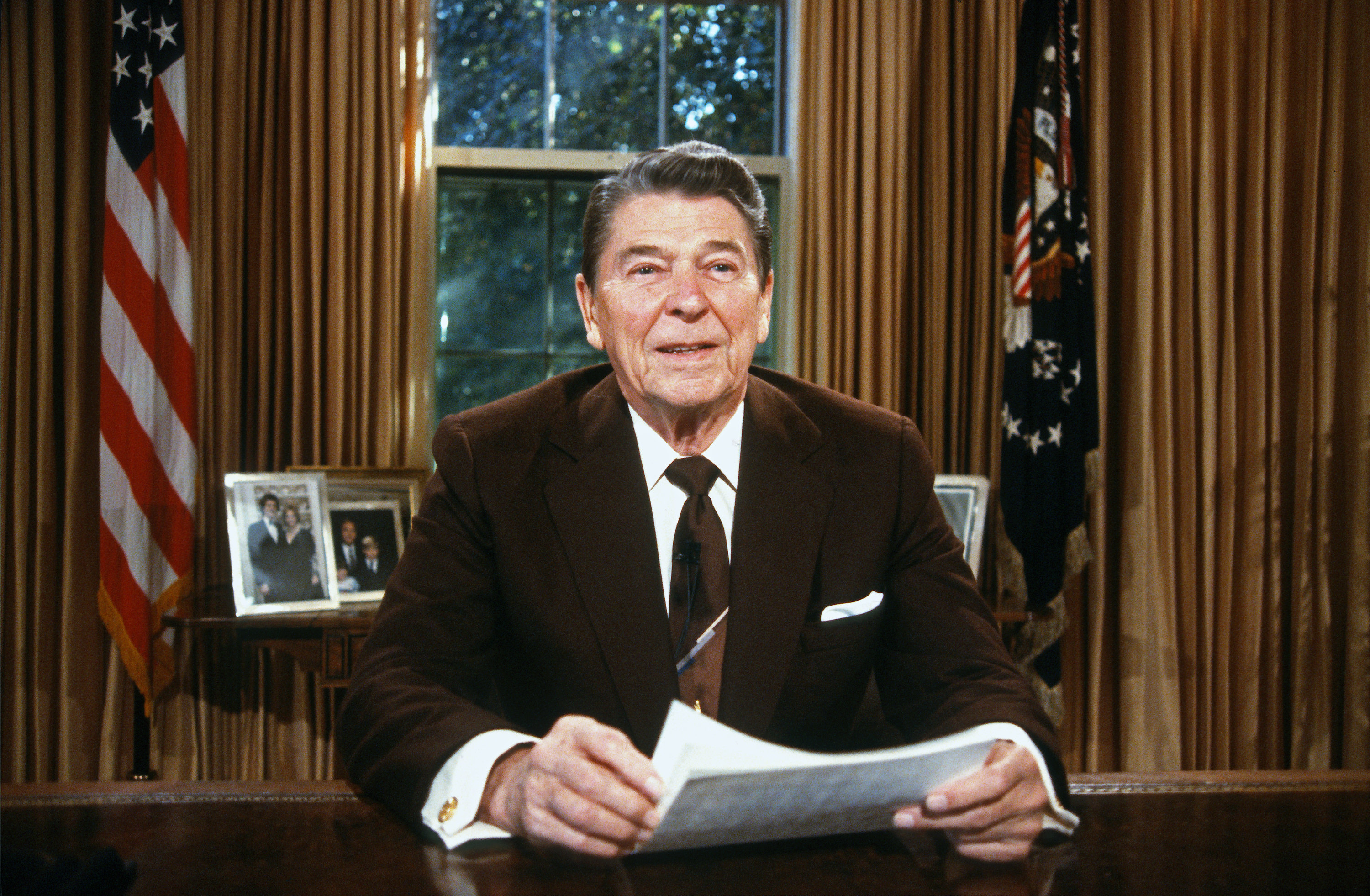 Ronald Reagan sitting in the Oval Office