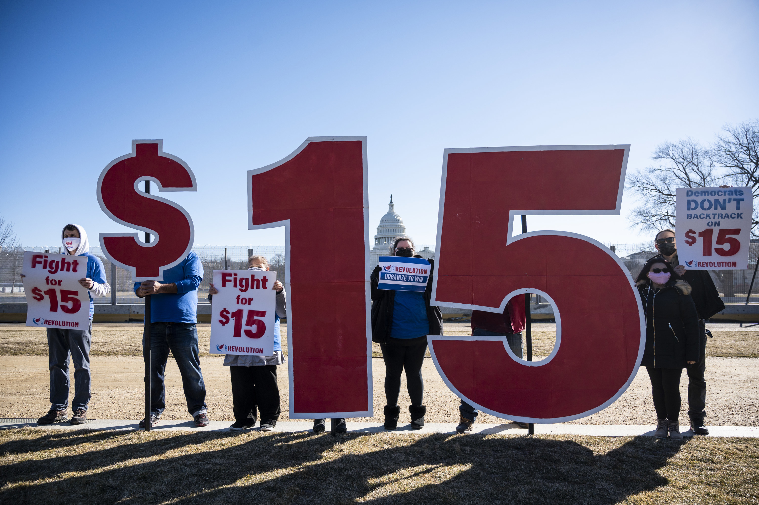 Activists outside Congress with signs supporting a $15 minimum wage in the US