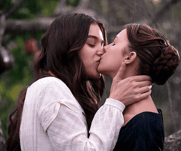 Emily and Sue secretly kissing in the rain