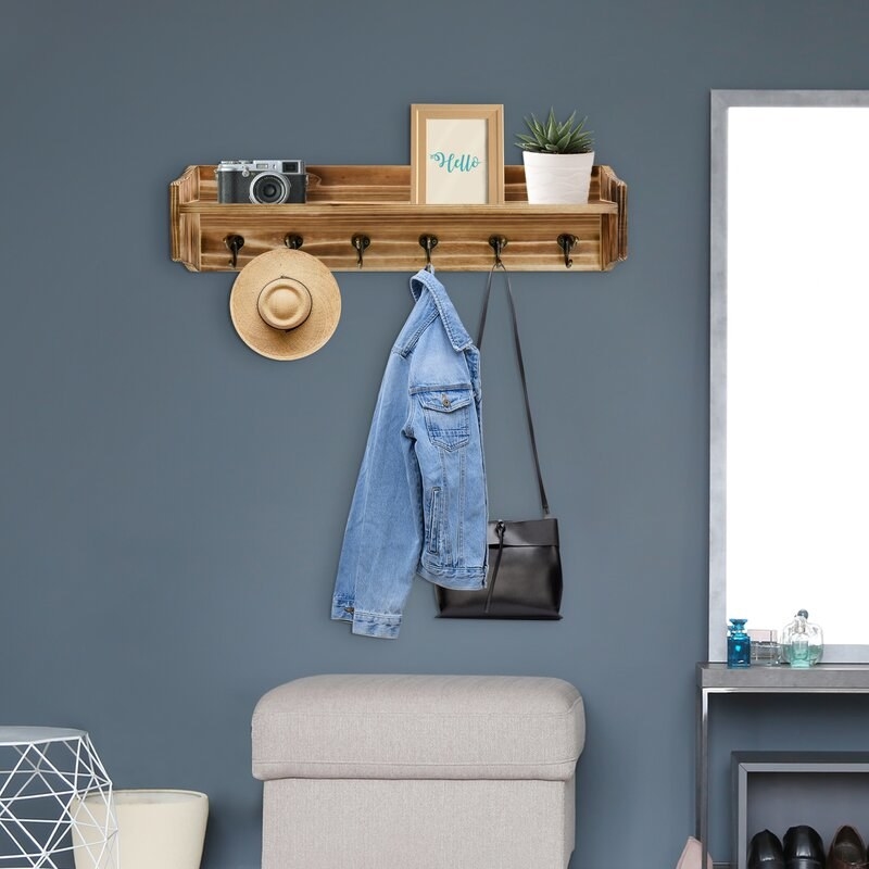 The wall mounted coat rack with a few items on it