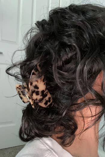 a reviewer with curly hair wearing the clip