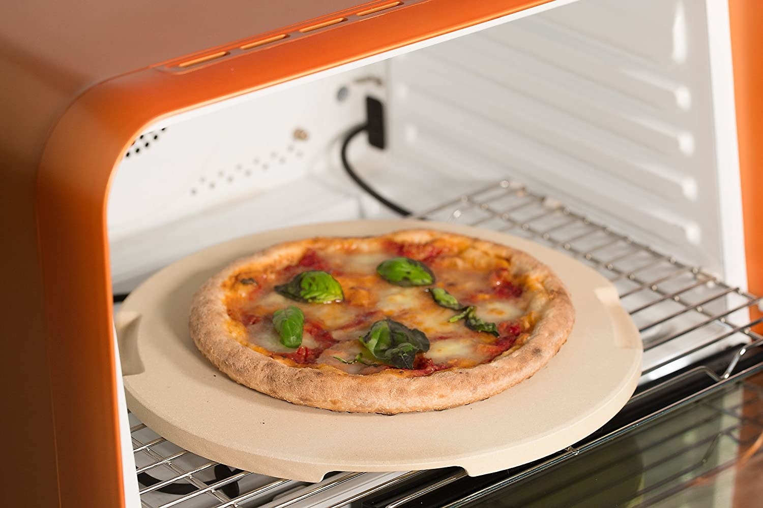 A pizza stone with a pizza on it in an oven