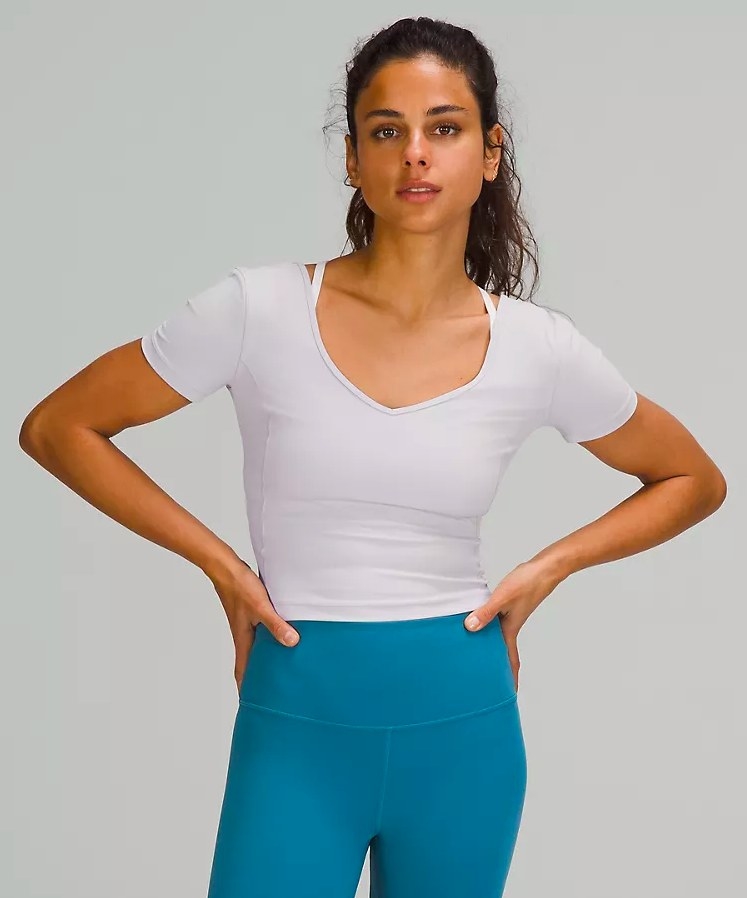 Model wearing white t-shirt and teal leggings