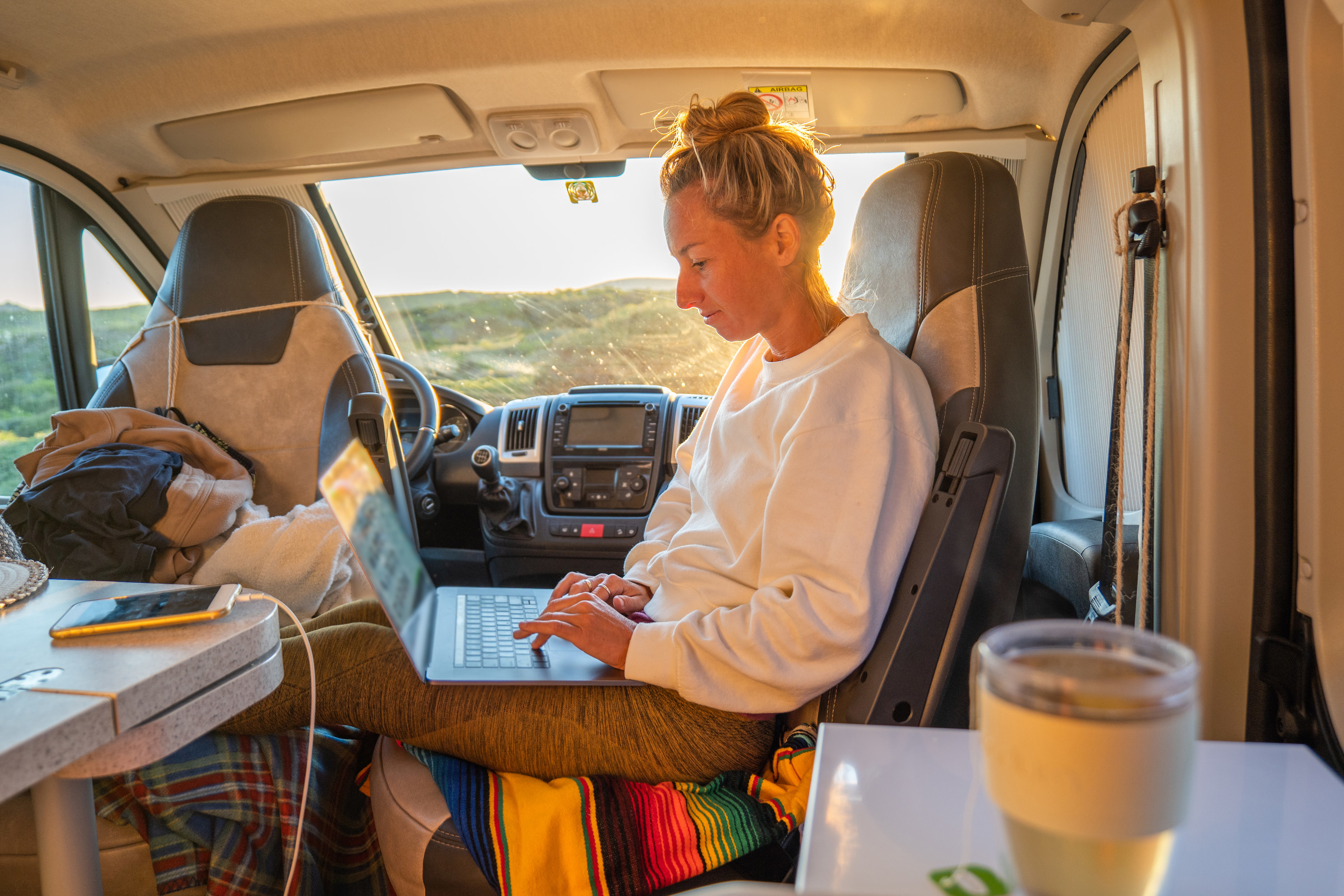 Woman working on a laptop in a van