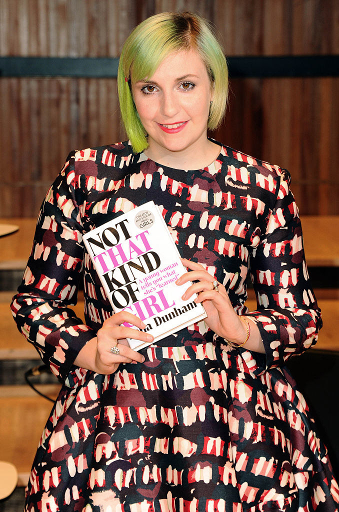 Lena Dunham holding her book