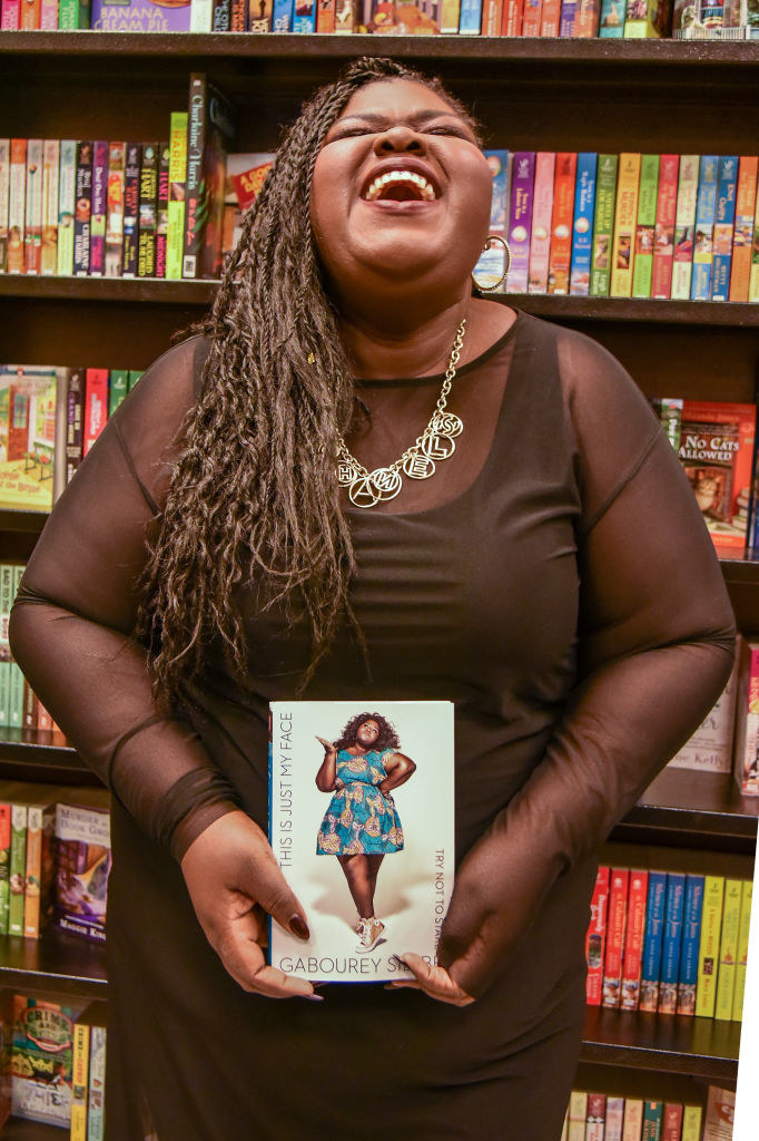 Gabourey holding her book in a bookstore