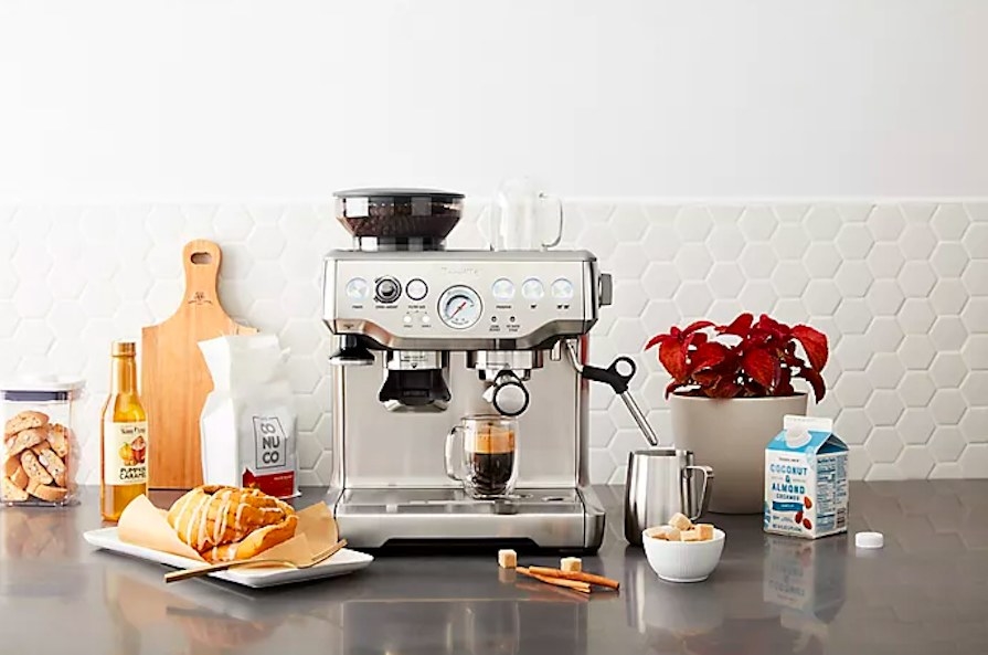 Espresso machine on a counter next to coffee products and other kitchen items