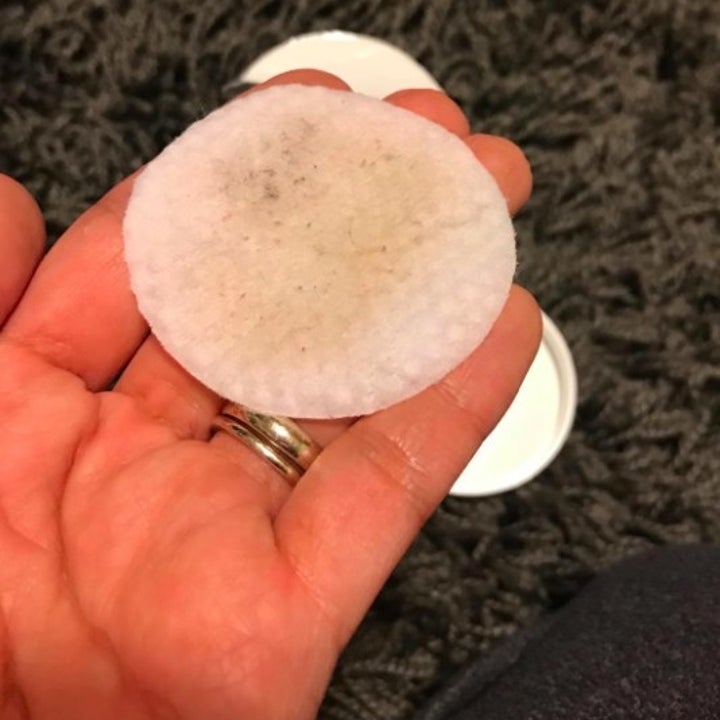 reviewer showing the pad with leftover makeup on it