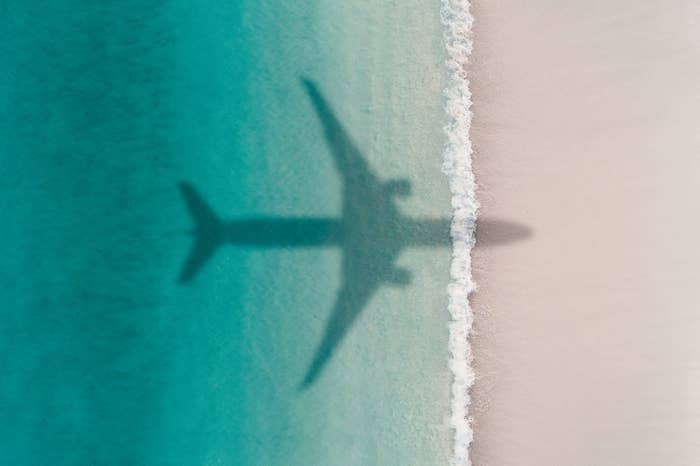 shadow of an airplane over water and beach