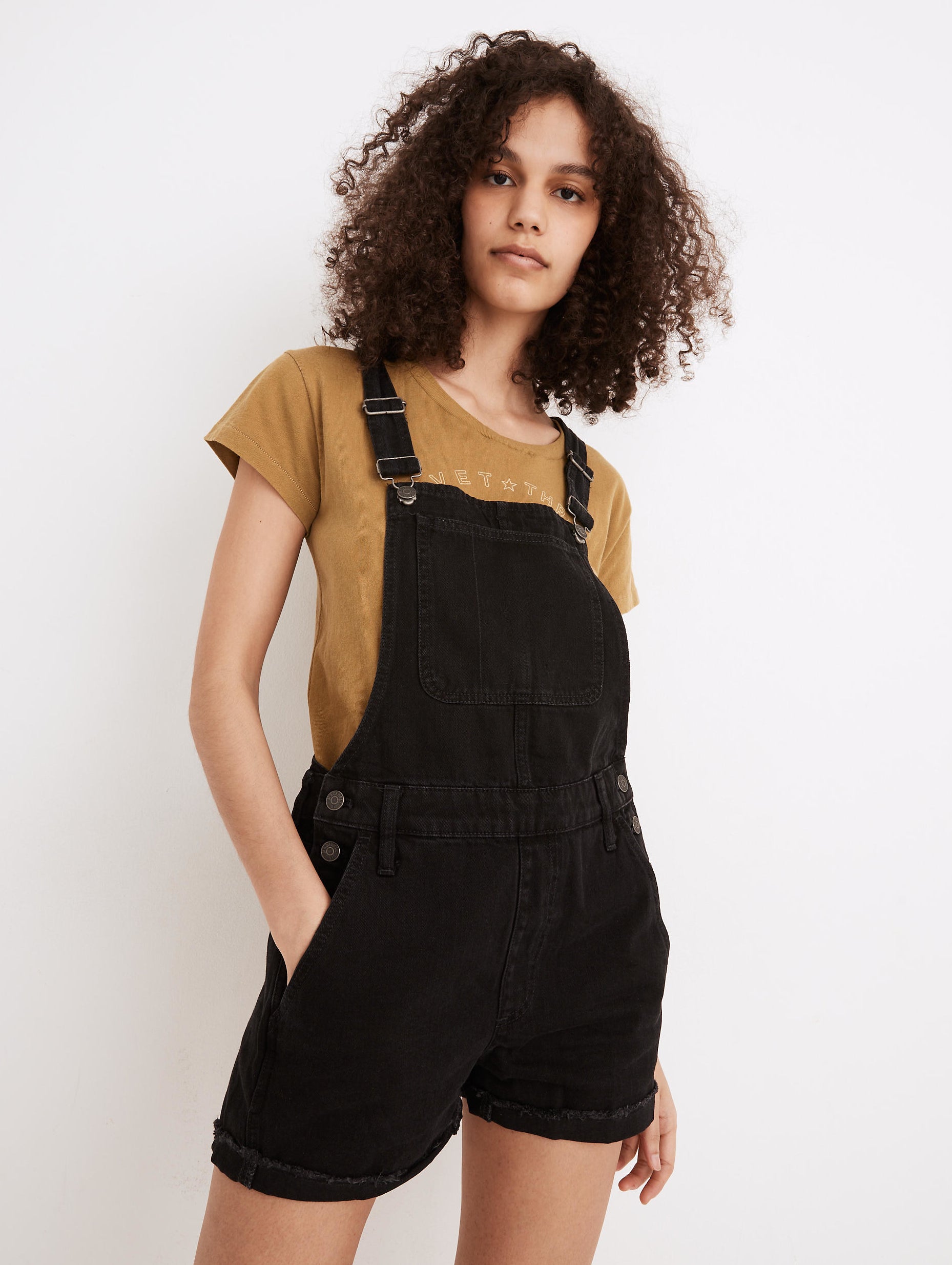 model in black denim short overalls