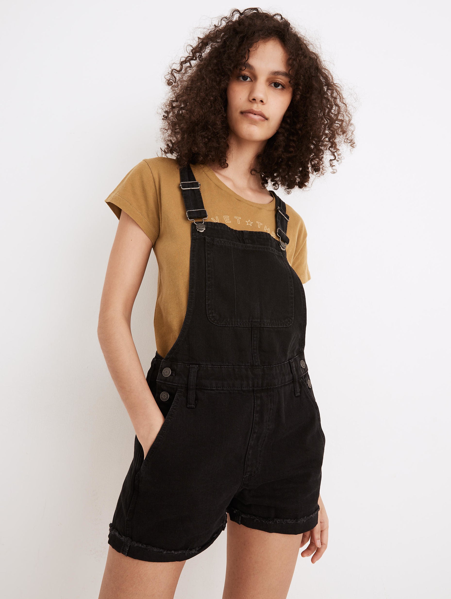 model in black denim short overalls