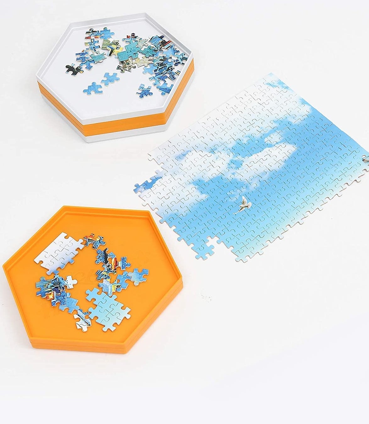 A puzzle with pieces sitting a hexagonal tray next to it