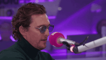 wearing a turtleneck and huge sunglasses to a radio interview, Matthew adorably laughs into the microphone
