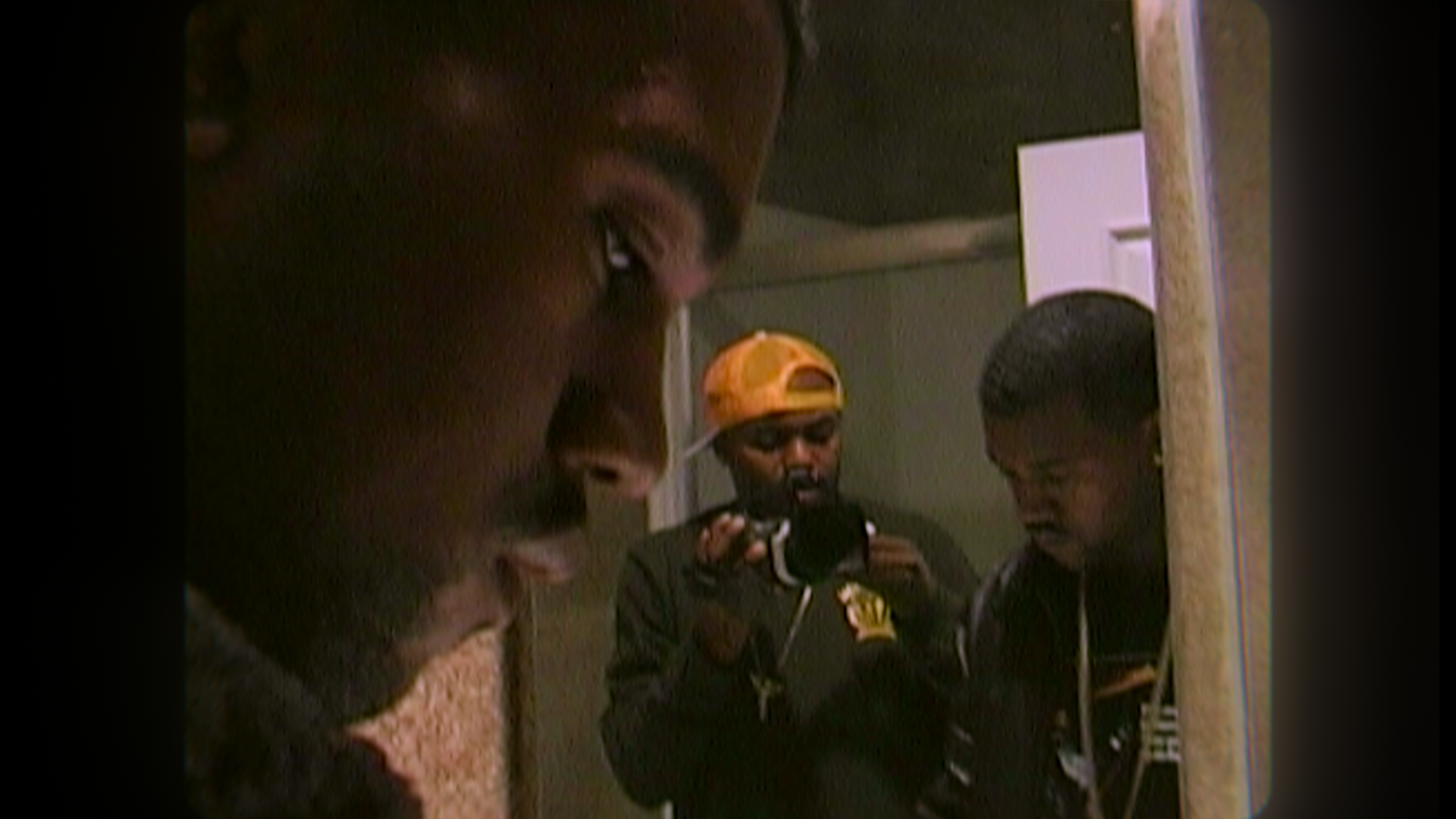 In the background, a mirror shows the reflection of Ye and a man filming him with a camera; Ye&#x27;s downturned profile is seen in the foreground