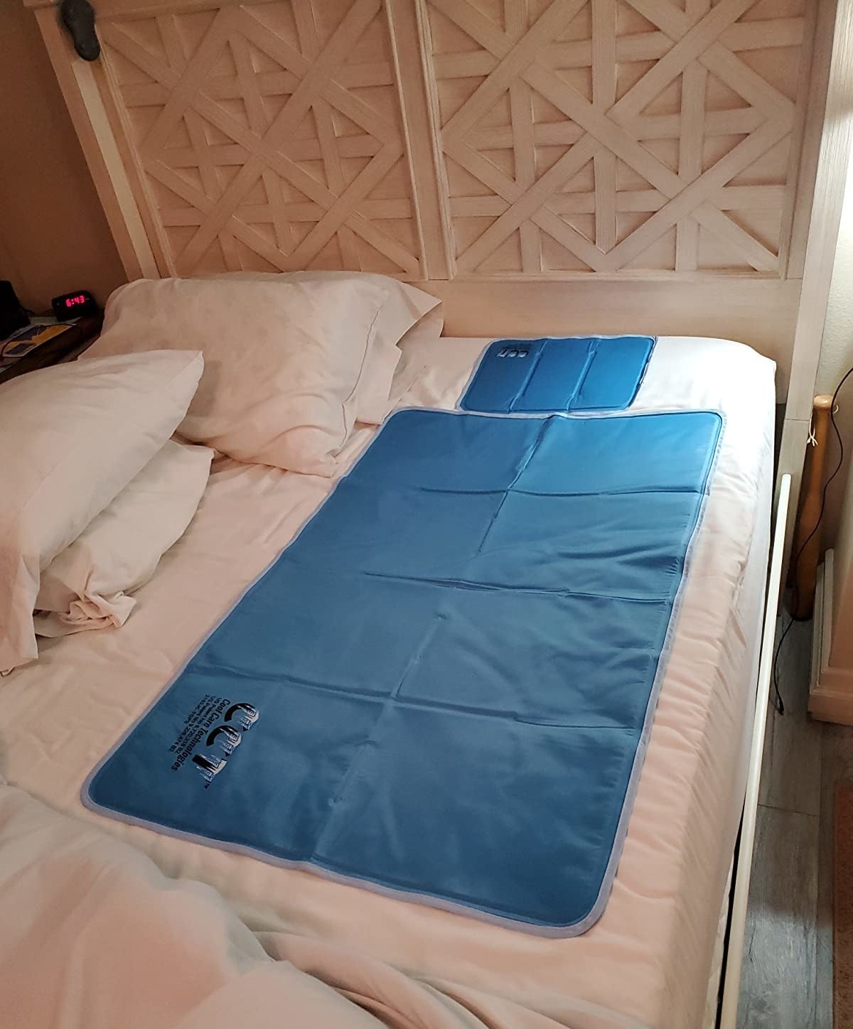 reviewer photo of the cooling pad and pillow pad on their bed